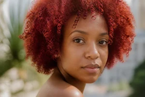 Portrait d'une femme à la peau noire et aux cheveux roux naturels en lumière douce
