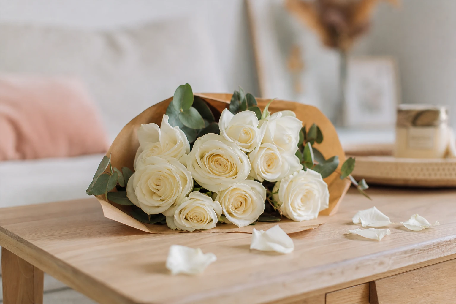 Bouquet de roses blanches fraîches posé sur une table en bois, symbole de pureté et de sincérité